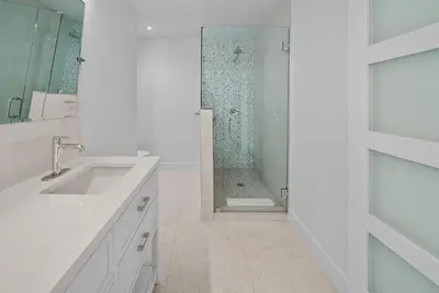 a white bathroom with a shower and a sink at Three Steps to the Beach l Beachfront l Steps To The Beach l Includes 2 Bikes in Inlet Beach