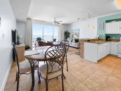 a kitchen and dining room with a table and chairs at Tidewater 311 l Beachfront with pristine views l Heated Pool & Jacuzzi l Gym and Game room and Theatre in Panama City Beach