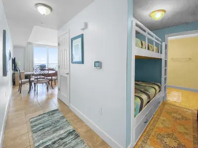 a bedroom with a bed and a dining room at Tidewater 311 l Beachfront with pristine views l Heated Pool & Jacuzzi l Gym and Game room and Theatre in Panama City Beach