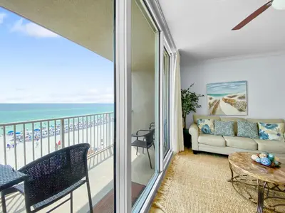 a living room with a view of the ocean at Tidewater 311 l Beachfront with pristine views l Heated Pool & Jacuzzi l Gym and Game room and Theatre in Panama City Beach
