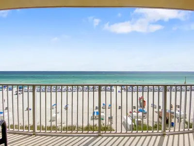 a balcony with a view of the beach and the ocean at Tidewater 311 l Beachfront with pristine views l Heated Pool & Jacuzzi l Gym and Game room and Theatre in Panama City Beach