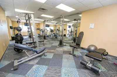a fitness room with several treadmills and machines at Tidewater 311 l Beachfront with pristine views l Heated Pool & Jacuzzi l Gym and Game room and Theatre in Panama City Beach