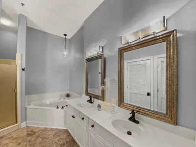 a bathroom with a sink and a tub and a mirror at Twickenham l Heated Community Pool l Private Balcony l Close to Rosemary in Rosemary Beach