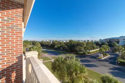 a view of a street with palm trees and a building at Twickenham l Heated Community Pool l Private Balcony l Close to Rosemary in Rosemary Beach