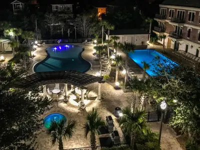an overhead view of a swimming pool at night at Twickenham l Heated Community Pool l Private Balcony l Close to Rosemary in Rosemary Beach