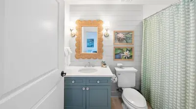 a bathroom with a sink and a toilet and a mirror at Vitamin Sea l Beachfront l 4 Bikes Included in Inlet Beach