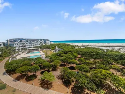an aerial view of a resort with trees and the beach at Vitamin Sea l Beachfront l 4 Bikes Included in Inlet Beach