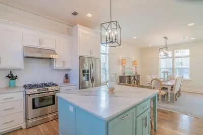 a kitchen with white cabinets and a blue island at Young Haven l Community Pool l Great Beach house Next to Seaside in Santa Rosa Beach
