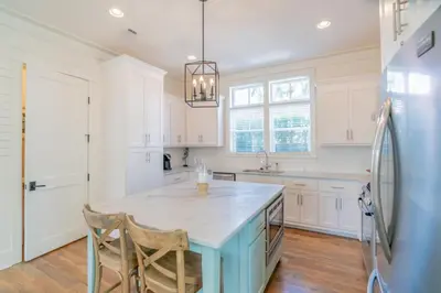 a kitchen with a blue island and a refrigerator at Young Haven l Community Pool l Great Beach house Next to Seaside in Santa Rosa Beach