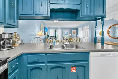 a kitchen with blue cabinets and a sink at Laguna Beach Breeze in Panama City Beach