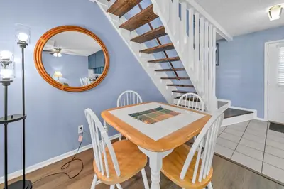 a dining room with a table and chairs and a mirror at Laguna Beach Breeze in Panama City Beach