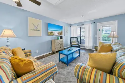 a living room with two couches and a table at Laguna Beach Breeze in Panama City Beach