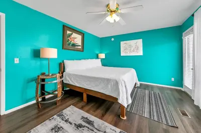 a bedroom with a bed and a blue wall at Laguna Beach Breeze in Panama City Beach
