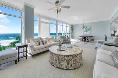a living room with white furniture and a table at Sterling Reef 301 by Emerald Coast Retreats in Panama City Beach