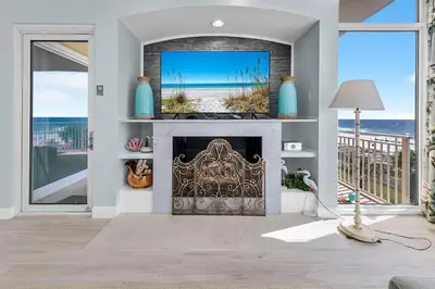 a living room with a fireplace with a tv above it at Sterling Reef 301 by Emerald Coast Retreats in Panama City Beach