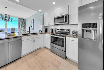 a kitchen with white cabinets and stainless steel appliances at Sterling Reef 301 by Emerald Coast Retreats in Panama City Beach