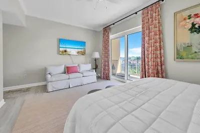 a white bedroom with a large bed and a couch at Sterling Reef 301 by Emerald Coast Retreats in Panama City Beach