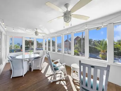 a dining room with a table and chairs and windows at Lagerheads l Beach Views l Private Pool l Dog Friendly l Includes 4 Bikes in Inlet Beach