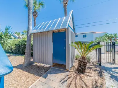 a smallshed with a blue door next to palm trees at Lagerheads l Beach Views l Private Pool l Dog Friendly l Includes 4 Bikes in Inlet Beach