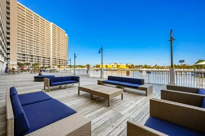 a rooftop patio with blue couches and tables at Laketown Wharf 531 in Panama City Beach