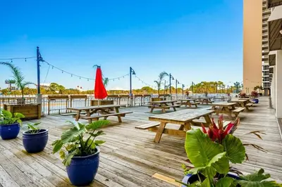 a deck with wooden picnic tables and potted plants at Laketown Wharf 531 in Panama City Beach