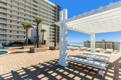 a white pergola with a bench and a building at Laketown Wharf 531 in Panama City Beach
