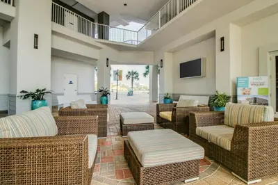 a lobby with wicker chairs and tables and a tv at Laketown Wharf 531 in Panama City Beach
