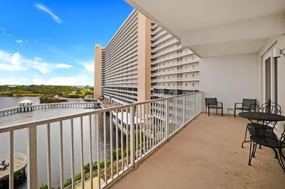 a balcony with tables and chairs and a view of the water at Laketown Wharf 531 in Panama City Beach