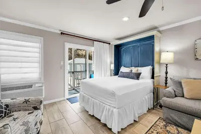 a bedroom with a bed and a couch and a window at Inlet Sands 105 in Rosemary Beach