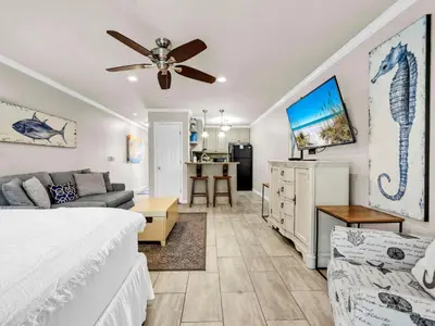 a bedroom with a bed and a living room at Inlet Sands 105 in Rosemary Beach