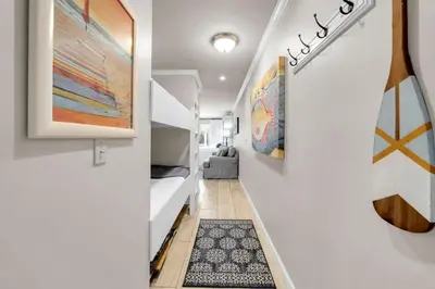 a hallway leading to a bedroom with a bed and a rug at Inlet Sands 105 in Rosemary Beach