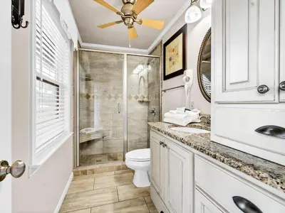 a white bathroom with a shower and a toilet at Inlet Sands 105 in Rosemary Beach
