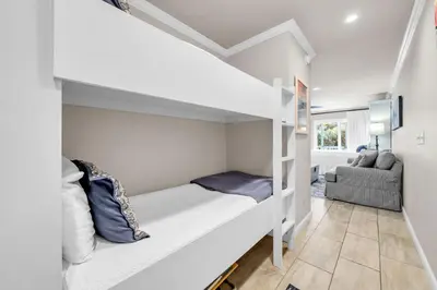a small bedroom with a bunk bed and a couch at Inlet Sands 105 in Rosemary Beach