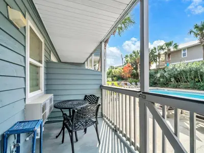 a balcony with a table and chair and a swimming pool at Inlet Sands 105 in Rosemary Beach