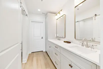 a white bathroom with two sinks and a large mirror at HP 42W Peaceful Nest by 30A Escapes in Rosemary Beach