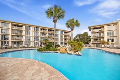 a swimming pool in front of a building with palm trees at HP 42W Peaceful Nest by 30A Escapes in Rosemary Beach