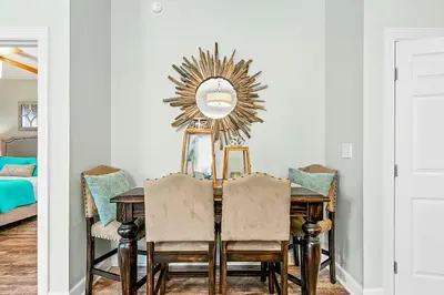 a dining room with a table with chairs and a mirror at Paradise 2205 in Santa Rosa Beach