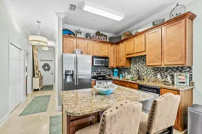 a kitchen with wooden cabinets and a granite counter top at Paradise 2205 in Santa Rosa Beach