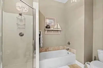 a white bathroom with a tub and a toilet at Paradise 2205 in Santa Rosa Beach