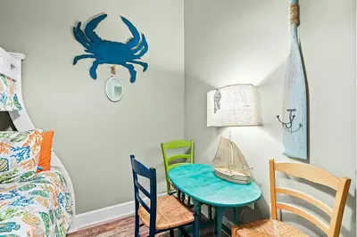 a room with a table and chairs and a spider on the wall at Paradise 2205 in Santa Rosa Beach