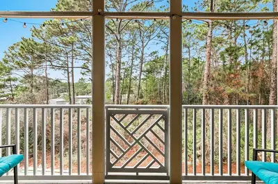 a screened porch with a view of the woods at Paradise 2205 in Santa Rosa Beach