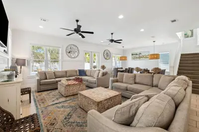 a living room with two couches and a table at Pelican Perch in Seagrove Beach
