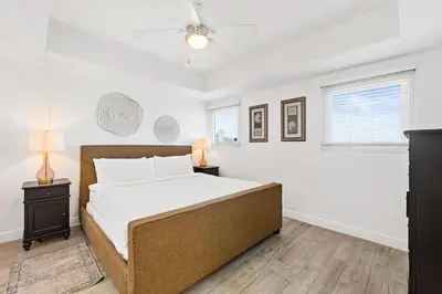 a bedroom with a large bed and two windows at Sterling Breeze 307A by Emerald Coast Retreats in Panama City Beach