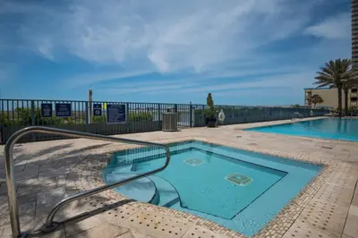 a swimming pool with a metal railing next to a fence at Sterling Breeze 307A by Emerald Coast Retreats in Panama City Beach