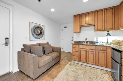 a living room with a couch and a kitchen at Sterling Breeze 307A by Emerald Coast Retreats in Panama City Beach