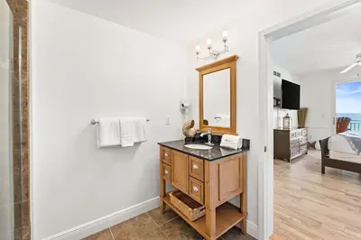 a bathroom with a sink and a mirror on a wall at Sterling Breeze 307B by Emerald Coast Retreats in Panama City Beach