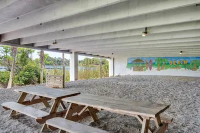 a picnic table and two benches in front of a building at Sterling Breeze 307B by Emerald Coast Retreats in Panama City Beach