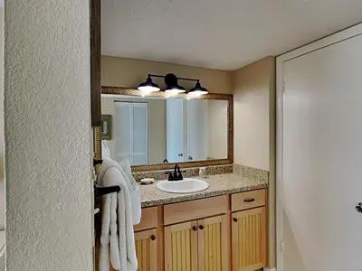 a bathroom with a sink and a mirror at Dunes of Panama #B501 in Panama City Beach