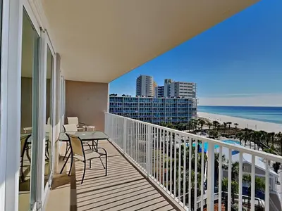 a balcony with a table and chairs and the beach at Dunes of Panama #B501 in Panama City Beach