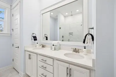 a white bathroom with two sinks and a mirror at Blue Dreams 125 W Pine Lands Loop Unit A in Inlet Beach